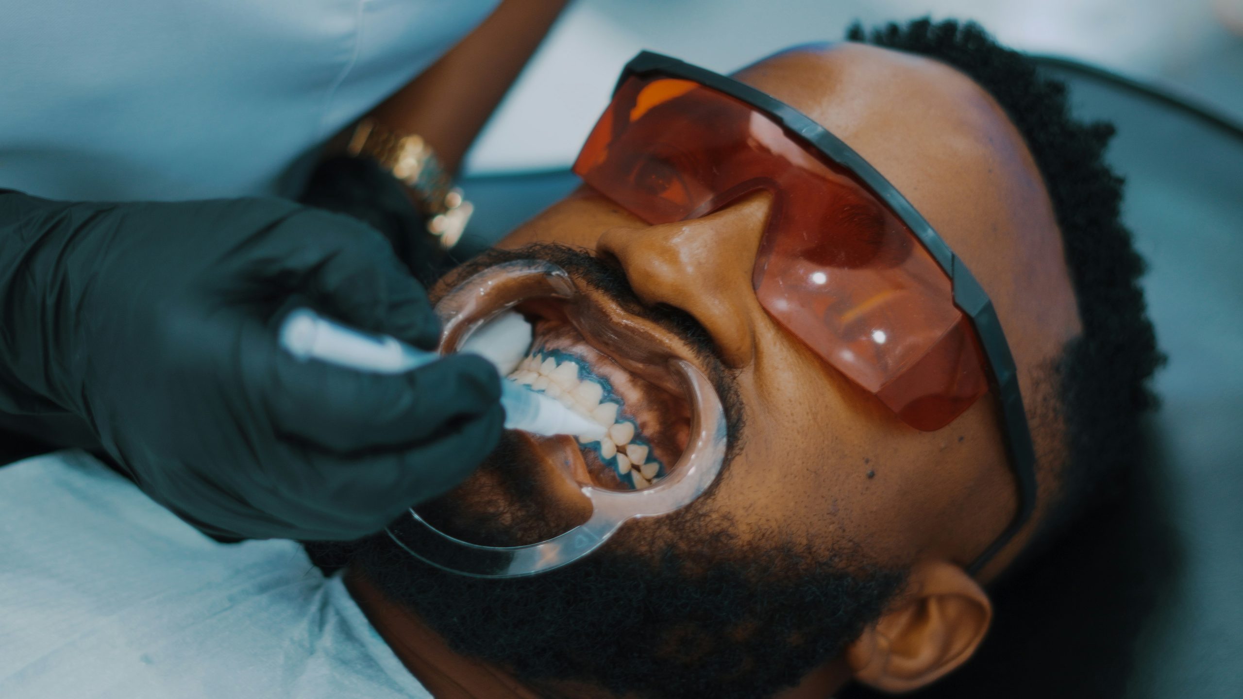 how long does teeth whitening last — patient receiving professional in-chair whitening treatment