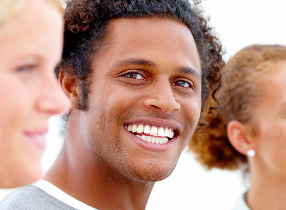 Smiling man with natural-looking teeth representing a confident All-on-4 dental implant patient at Bradstowe Dental in Woking and Surrey