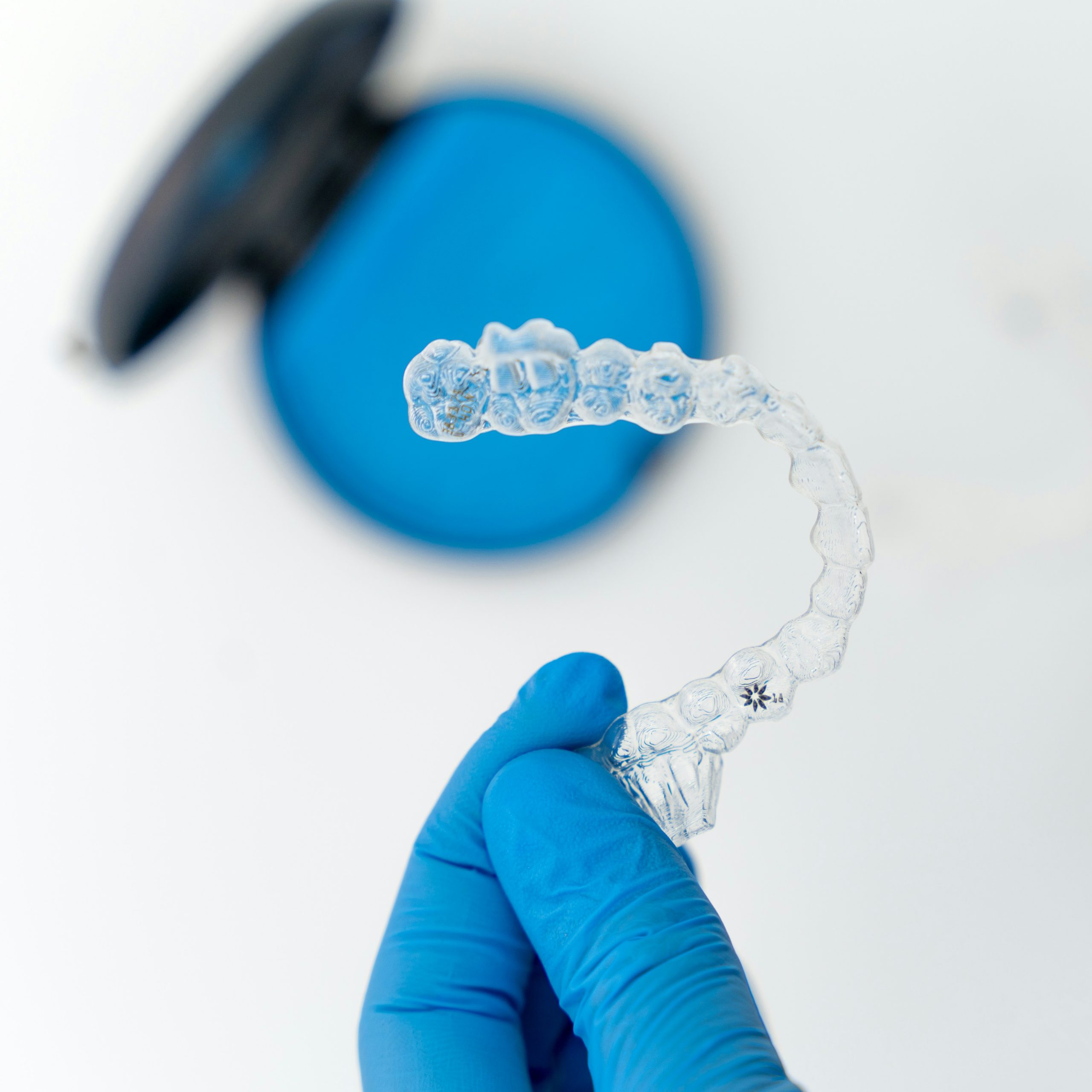 Dental professional holding an Invisalign clear aligner at Bradstowe Dental in Woking