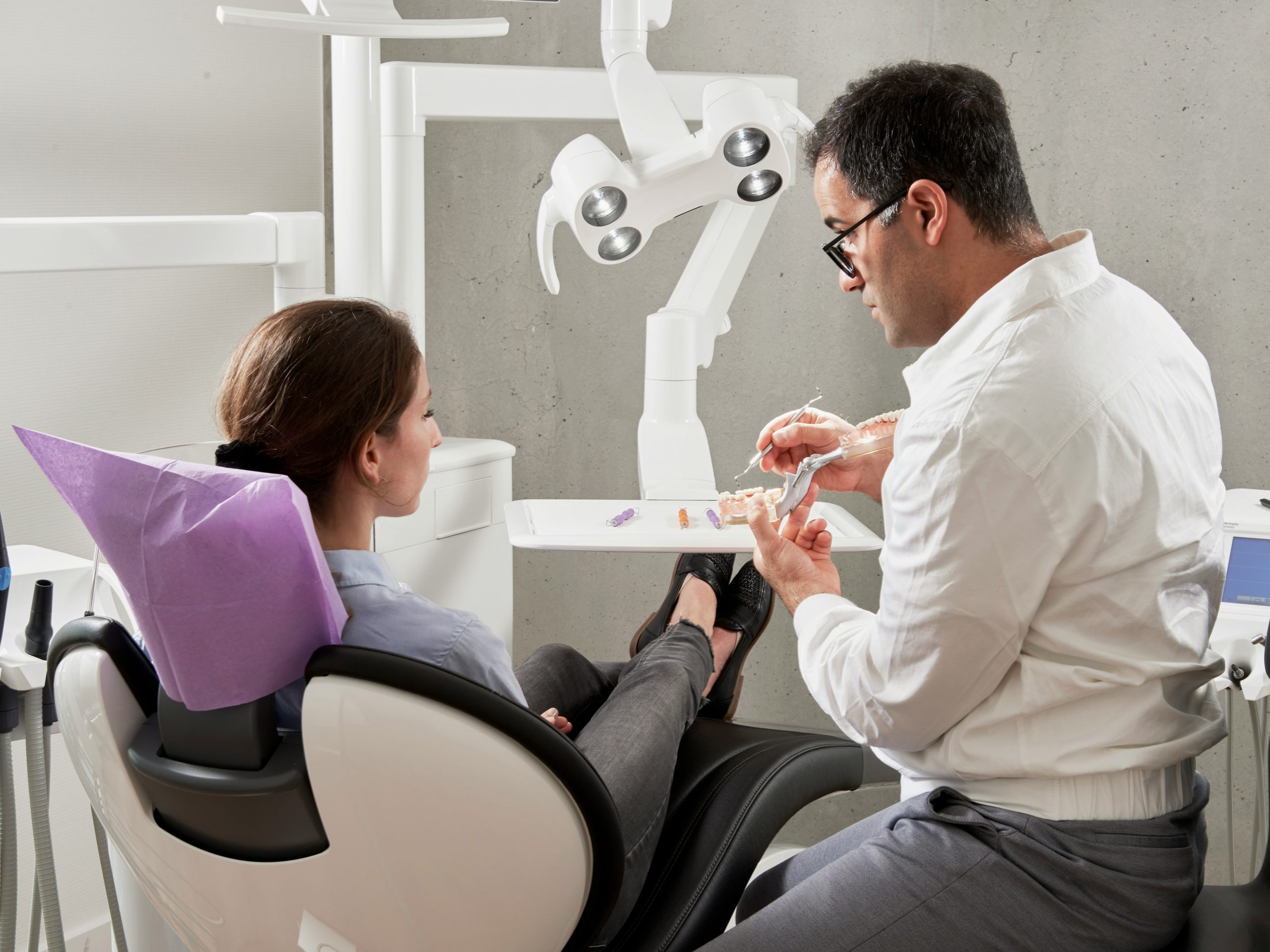 Dentist showing a dental model to a nervous patient discussing sedation for dental implants